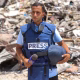 An image of Journalist Anas al-Sharif standing in front of Rubble in Gaza